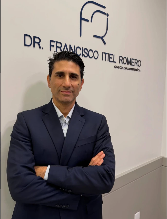 Dr. Francisco Itiel Romero de terno, em frente à parede com seu nome e especialidade